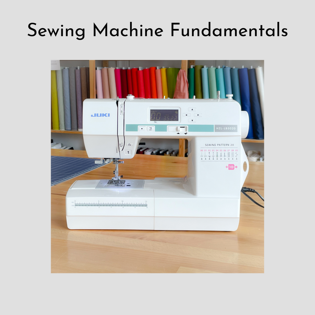 There is a photo of a Juki sewing machine on a wood table with shelves of colorful bolts of fabric in the background. There is a thick, light grey border around the photo with the title above the photo that says "Sewing Machine Fundamentals".